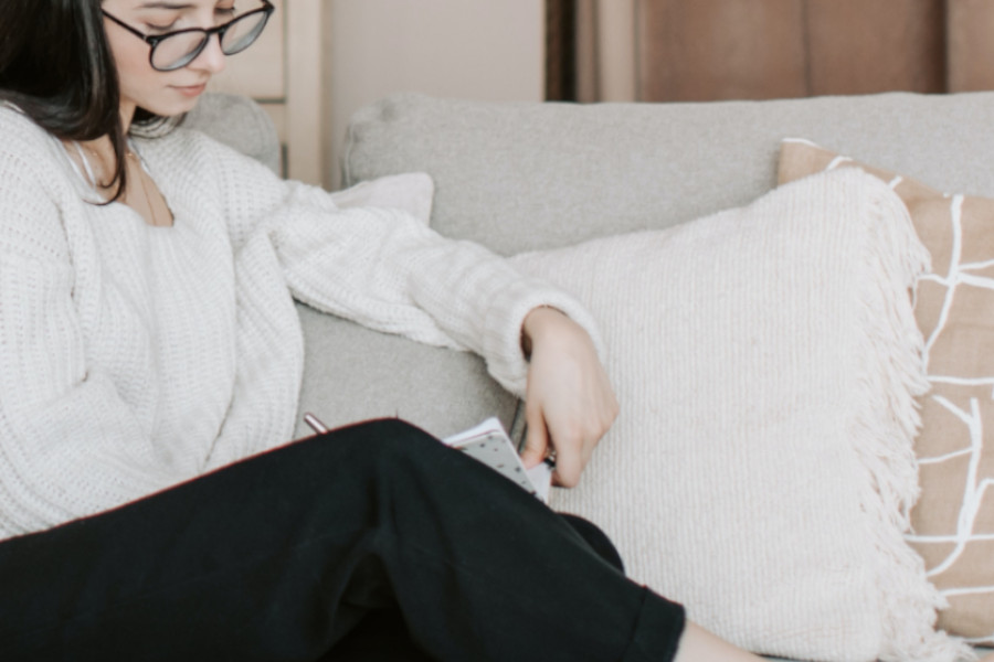 woman journaling on a couch